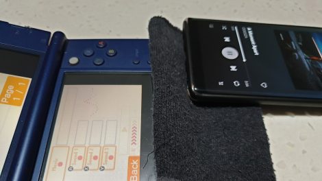 A phone on a sock, which is on a 3DS.